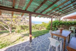 une table et des chaises en bois sous une pergola dans l'établissement Appartamenti La Zanca, à Zanca