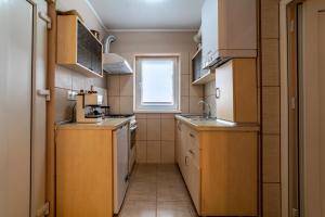 a small kitchen with wooden cabinets and a window at CASA SPERANTEI in Sighişoara