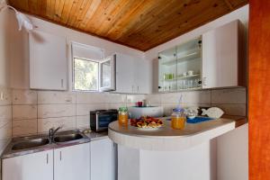 a kitchen with white cabinets and a sink and a counter at Azzure Apartment in Ulcinj