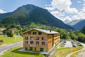 a hotel in the mountains with a parking lot at Explorer Hotel Montafon in Gaschurn