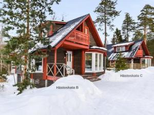una cabaña de madera con nieve delante en Holiday Home Hästöskata b by Interhome en Kruunupyy