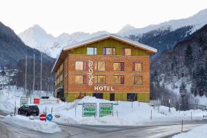 ein Hotel in den Bergen mit Schnee auf dem Boden in der Unterkunft Explorer Hotel Montafon in Gaschurn