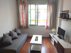 sala de estar con sofá y mesa en ENJOY apart Centro y Playa VICTORIA en Málaga