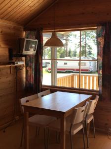 a dining room with a table and chairs and a window at Osensjøen Camping in Valmen