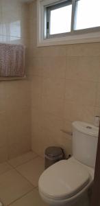 a bathroom with a white toilet and a window at EMILIA 10 STUDIO in Polis Chrysochous