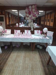 una mesa con un oso de peluche y globos en ella en Westmotelrestaurant, en Pădurea Urziceni