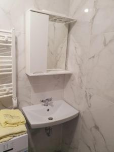 Baño blanco con lavabo y espejo en VIP apartment in the centre, en Uzhhorod