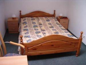 een slaapkamer met een houten bed met 2 nachtkastjes bij MOSiR Reda in Reda