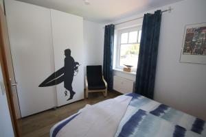 a bedroom with a silhouette of a surfer on the wall at GODS06004-FeWo-de-Klipp in Gollendorf