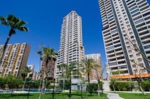 un parque con palmeras y edificios altos en Apartamentos con terraza Torre D'Oboe by Renthas, en Benidorm