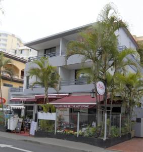 un edificio con palmeras delante en Apartamentos Turísticos Vitoria by Petit Hotels en Funchal