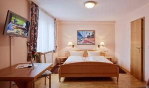 a hotel room with a bed and a desk at Weingut Gästehaus Derkum in Ürzig