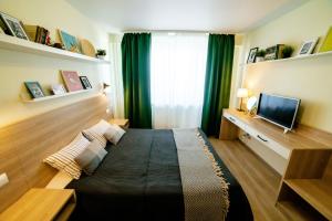 イジェフスクにあるOpenApart - Семейное гнездоのベッド1台とテレビが備わる小さな客室です。