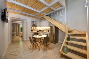 a kitchen and living room with a staircase and a table at La Soffitta in Benitses