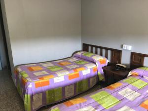 a bedroom with two beds and a blue blanket at Hostal San Miguel in León