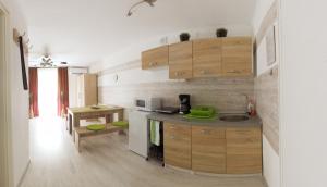 a kitchen with wooden cabinets and a counter top at Orchidea apartman in Harkány