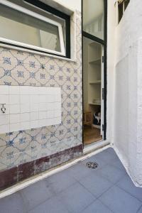 Habitación con ventana y pared de azulejos. en Amazing Grace - Checkinhome, en Lisboa