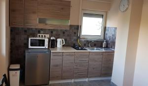 a kitchen with wooden cabinets and a microwave on a refrigerator at TimiBá in Zalakaros