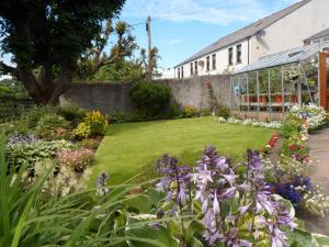ein Garten vor einem Gebäude mit Blumen in der Unterkunft Nethercliffe Hotel in Wick