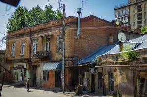 un antiguo edificio de ladrillo en una calle de la ciudad en Old Tbilisi apartments en Tiflis