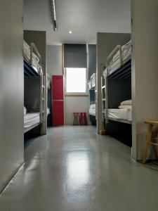 une chambre avec quatre lits superposés et une chambre avec une table dans l'établissement Acolá Hostel, à Pontevedra