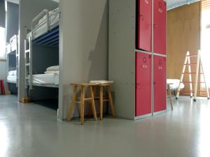 a room with bunk beds and a table and a stool at Acolá Hostel in Pontevedra