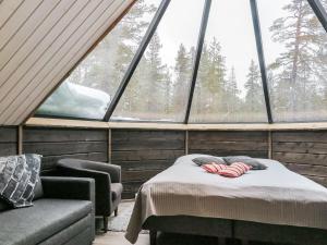 a room with a bed and a couch and a window at Holiday Home Arctic light hut by Interhome in Kakslauttanen