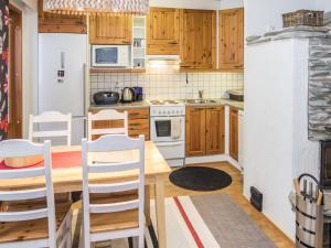 a kitchen with wooden cabinets and a table and chairs at Holiday Home Karhunvartijan linna a3 by Interhome in Ruka