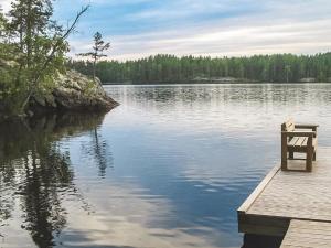 a bench sitting on a dock on a lake at Holiday Home Koholahti by Interhome in Jäniskylä