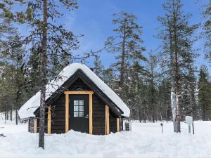 a small log cabin with snow on the roof at Holiday Home Arctic light hut by Interhome in Kakslauttanen