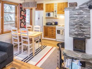 a kitchen and living room with a table and a fireplace at Holiday Home Karhunvartijan linna a3 by Interhome in Ruka