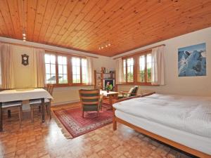 een slaapkamer met een bed, een tafel en een piano bij Apartment Chalet Bodenweg by Interhome in Frutigen