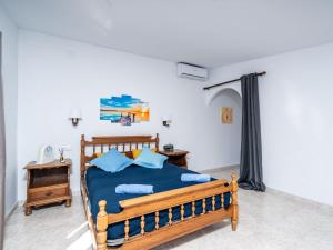 a bedroom with a wooden bed with blue sheets at Villa Aurelie by Interhome in Balcon del Mar