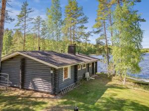 a tiny house on the shore of a lake at Holiday Home Aurinkoniemi by Interhome in Anttola