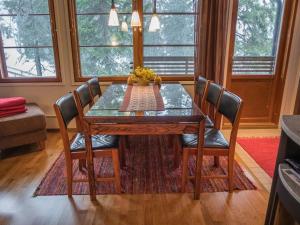 a dining room table with four chairs and a glass top at Holiday Home Karhunvartijan linna a7 by Interhome in Ruka
