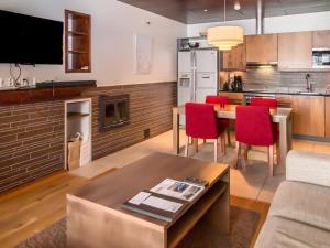 cocina y sala de estar con mesa y sillas rojas en Holiday Home Tahko spa junior suite orange b2 by Interhome, en Tahkovuori