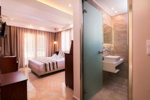 a bedroom with a bed and a bathroom with a sink at Hotel Diamond in Limenaria