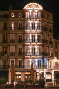 a large building with umbrellas in front of it at Hôtel Maison Saint Louis - Vieux Port in Marseille