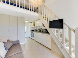a living room with a staircase with a flat screen tv at Studio Mas de la Plage by Interhome in Cavalaire-sur-Mer