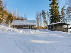 Cabaña de madera con techo cubierto de nieve junto a una carretera en Holiday Home Saarijärvi by Interhome, en Sipilä