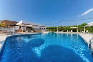 une grande piscine d'eau bleue dans l'établissement Hotel Torre De Los Guzmanes, à La Algaba