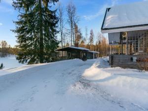 una casa cubierta de nieve junto a un edificio en Holiday Home Saarijärvi by Interhome, en Sipilä