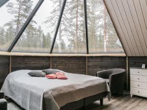 Schlafzimmer mit einem Bett vor einem großen Fenster in der Unterkunft Holiday Home Arctic light hut by Interhome in Kakslauttanen + 8 Fotos