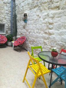 un patio con sillas coloridas, mesa y sillas en Apartment Nikolina, en Trogir