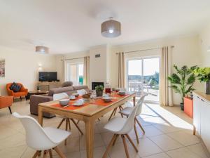 sala de estar con mesa de madera y sillas blancas en Holiday Home Vila Caravela by Interhome, en Estevais