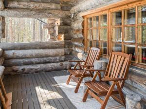 two rocking chairs on a porch of a log cabin at Holiday Home Suutarinkolo by Interhome in Levi
