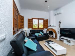 a living room with a black couch and a tv at Villa Aurelie by Interhome in Balcon del Mar