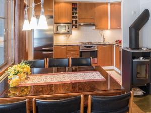 a kitchen with a table with chairs and a stove at Holiday Home Karhunvartijan linna a7 by Interhome in Ruka