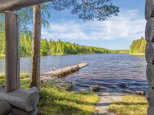 a dock on a lake with trees in the background at Holiday Home Aurinkoniemi by Interhome in Anttola