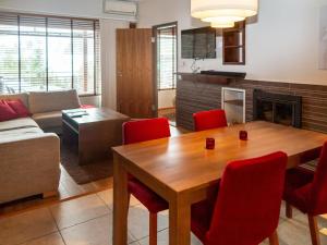 sala de estar con mesa de madera y sillas rojas en Holiday Home Tahko spa junior suite orange b2 by Interhome, en Tahkovuori